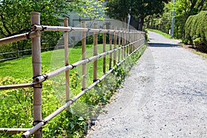 Bamboo fence is along ground road in countryside of small Japanese village. Japan