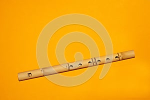 Bamboo flute. simple wind instrument on yellow background