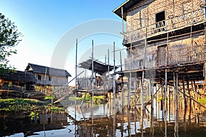 Bamboo houses on piles standing in water in township