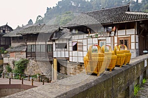 Bamboo lidded baskets on stone balustrade before ancient houses