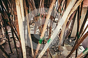 Bamboo logs in support for the freshly laid concrete roof in a under construction building