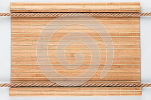 Bamboo mat with curled edges and two ropes