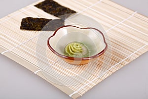 A bamboo mat and two laver and wasabi