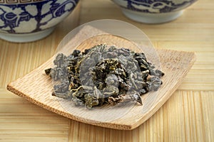 Bamboo plate with Chinese Ti Kuan Yin dried tea leaves close up