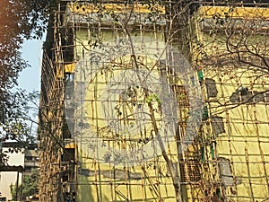 Bamboo Scaffolding on twenty-five-year-old four-storey building gating structural Repair work going on