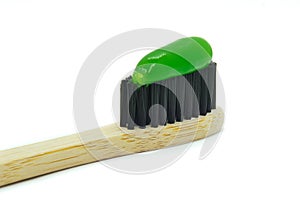 Bamboo toothbrush with green mint toothpaste isolated on white background.