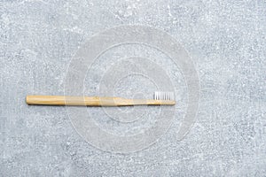 Bamboo toothbrush on grey background. Ecological and organic, zero waste concept