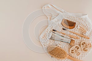 Bamboo toothbrush, toothpaste, natural brush, self-care cosmetics products and white cotton mesh bag on pale background