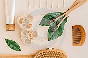 Bamboo toothbrush, toothpaste, natural brush, self-care cosmetics products and white cotton mesh bag on pale background