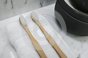 Bamboo toothbrush in white marble bathroom