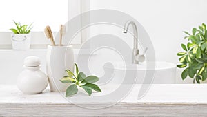 Bamboo toothbrushes in holder on table against blurred bathroom background