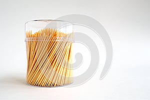 Bamboo toothpicks in a plastic lidded storage box on white background, copy space. photo