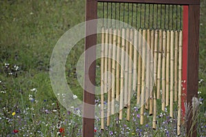 Bamboo Wind Chime on Wooden Frame with Greenery Background