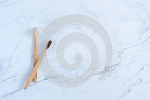 Bamboo wood toothbrush on clean white marble table top view background concept for save the earth day, world environmental,