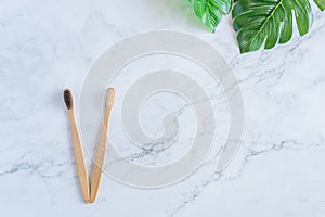 Bamboo wood toothbrush on clean white marble table top view background concept for save the earth day, world environmental,