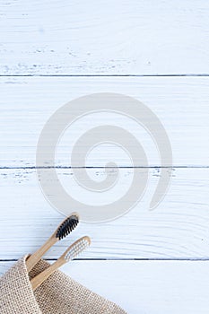 Bamboo wood toothbrush on clean white marble table top view background concept for save the earth day, world environmental,