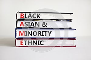 BAME symbol. Abbreviation BAME, black, asian and minority ethnic on books. Beautiful white background. Copy space. Business and photo