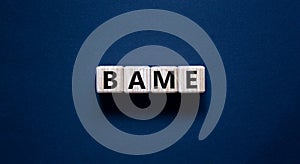 BAME symbol. Abbreviation BAME, black, asian and minority ethnic on wooden cubes. Beautiful grey background. Copy space. Business photo