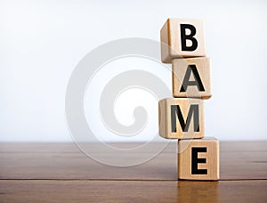 BAME symbol. Abbreviation BAME, black, asian and minority ethnic on wooden cubes. Beautiful wooden table, white background. Copy photo