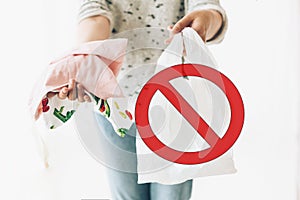 Ban single use plastic, stop sign. Zero Waste shopping concept. Woman holding in one hand groceries in reusable eco bag and in