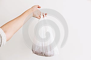 Ban single use plastic. Woman holding in hand groceries in plastic polyethylene bag. Zero Waste shopping concept.  Reuse, reduce,