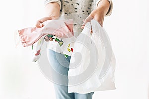 Ban single use plastic. Zero Waste shopping concept. Woman holding in one hand groceries in reusable eco bag and in other