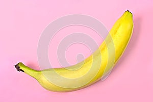 Banana against a bright pink background.