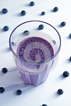 banana and blueberry smoothie in a glass cup with blueberries