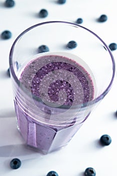 banana and blueberry smoothie in a glass cup with blueberries