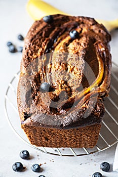 Banana bread with blurberries on a cooling rack on a gray background