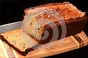Banana bread on a cutting board with a piece cut off