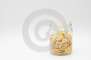 Banana chips in glass jar isolated on white backround