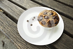 Banana cup cake with chocolate chip topping in white plate. Fresh banana cup cake in foil cup