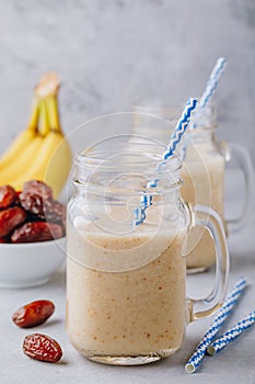 Banana and date fruit smoothie or milkshake in glass mason jar