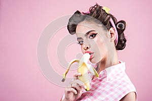 Banana dieting. pin up woman with trendy makeup. pinup girl with fashion hair. retro woman eating banana. pretty girl in photo