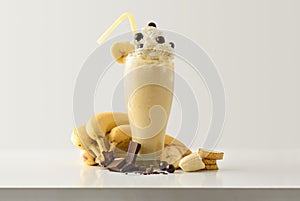 Banana milkshake with choco decorated with fruit on table isolated