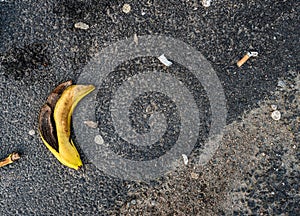 Banana peel, snuff, cigarette butt and other garbage on asphalt..