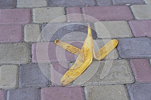 Banana peel was left on the pavement. The danger may slip. If anyone walks on it. Be careful of slippery. Closeup, outdoors