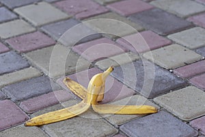 Banana peel was left on the pavement. The danger may slip. If anyone walks on it. Be careful of slippery. Closeup, outdoors
