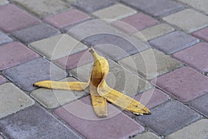 Banana peel was left on the pavement. The danger may slip. If anyone walks on it. Be careful of slippery. Closeup, outdoors