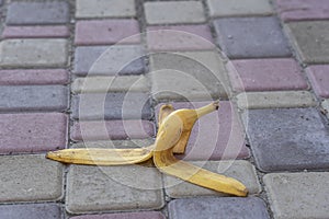 Banana peel was left on the pavement. The danger may slip. If anyone walks on it. Be careful of slippery. Closeup, outdoors