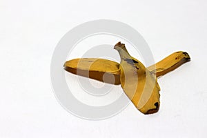 Banana peel was left on the white floor. The danger may slip.