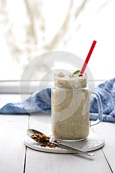 Banana smoothie with peanut butter, cinnamon and granola for healthy breakfast