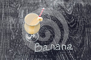 Banana smoothies and bananas on an old wooden background