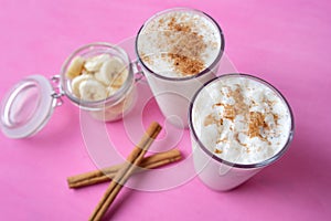 Banana smothie or milkshake with cinnamon on pink  background