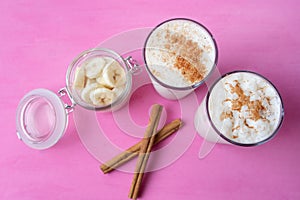 Banana smothie or milkshake with cinnamon on pink  background