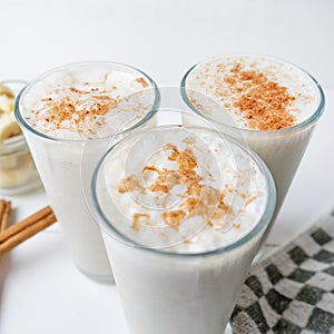Banana smothie or milkshake with cinnamon on white  background photo