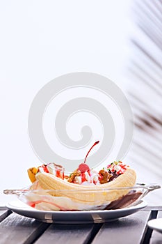 Banana split ice cream with whipped cream and cherry photo