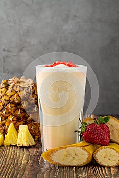 Banana, strawberry and pineapple smoothie on wooden table and bubble tea or boba tea balls on it