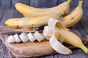 Bananas and banana slices on a wooden board